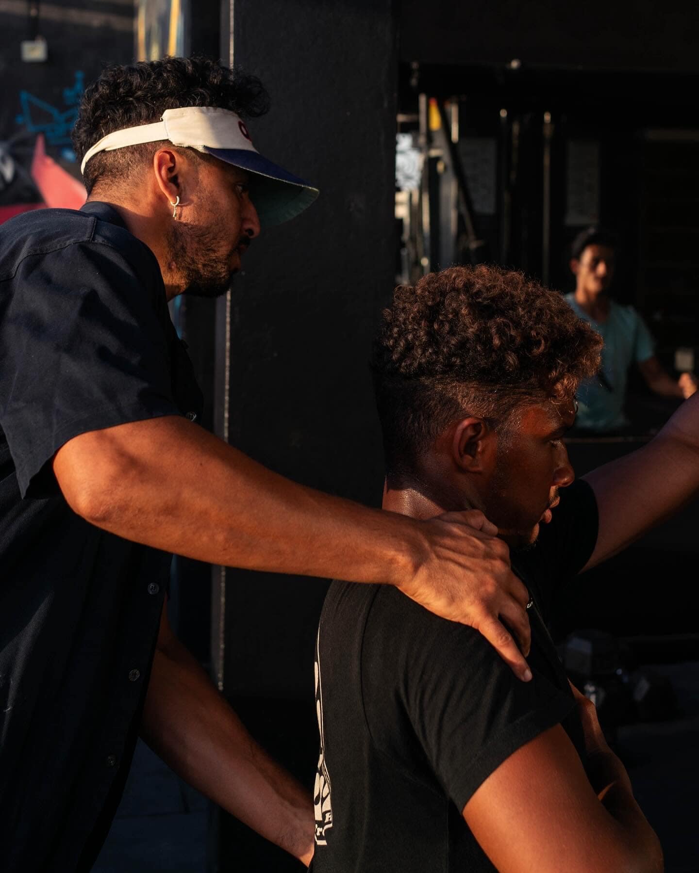 Coach adjusting a guest’s posture in the rooftop gym at golden hour