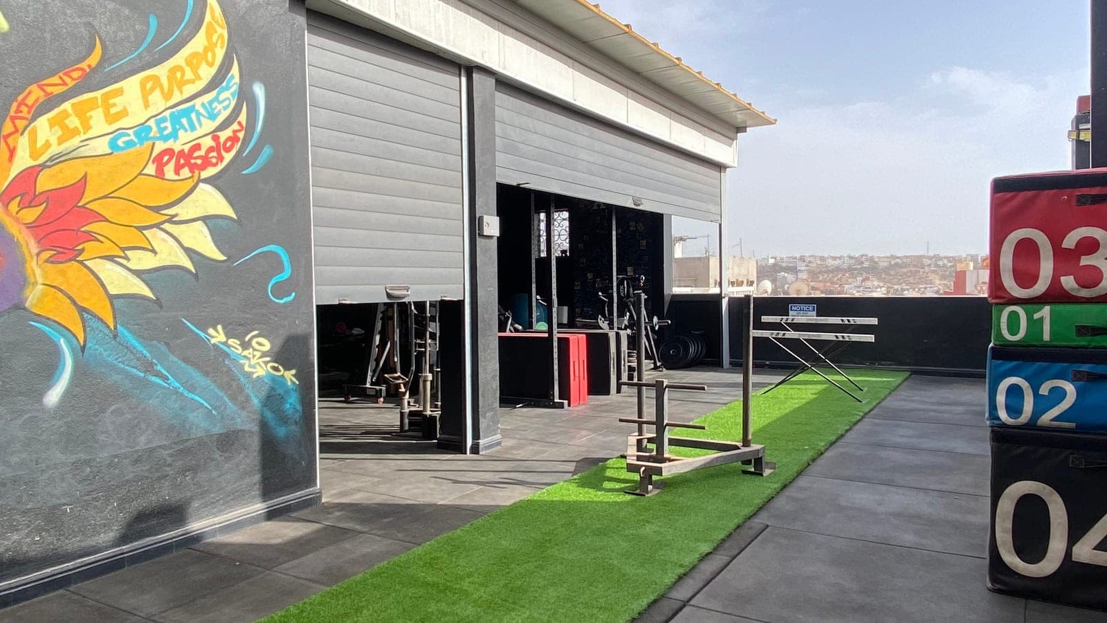 Couloir de turf, jumping boxes et espace conditioning sur le rooftop de jour