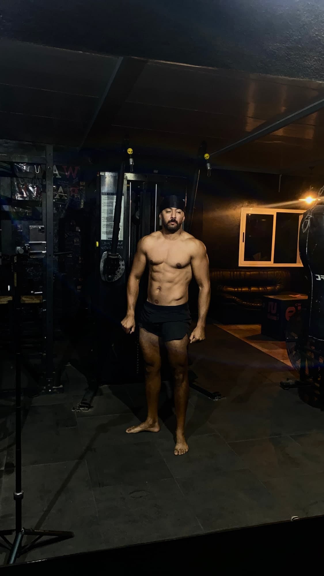 Yozi, coach de performance, en pied dans sa salle de sport privée de nuit